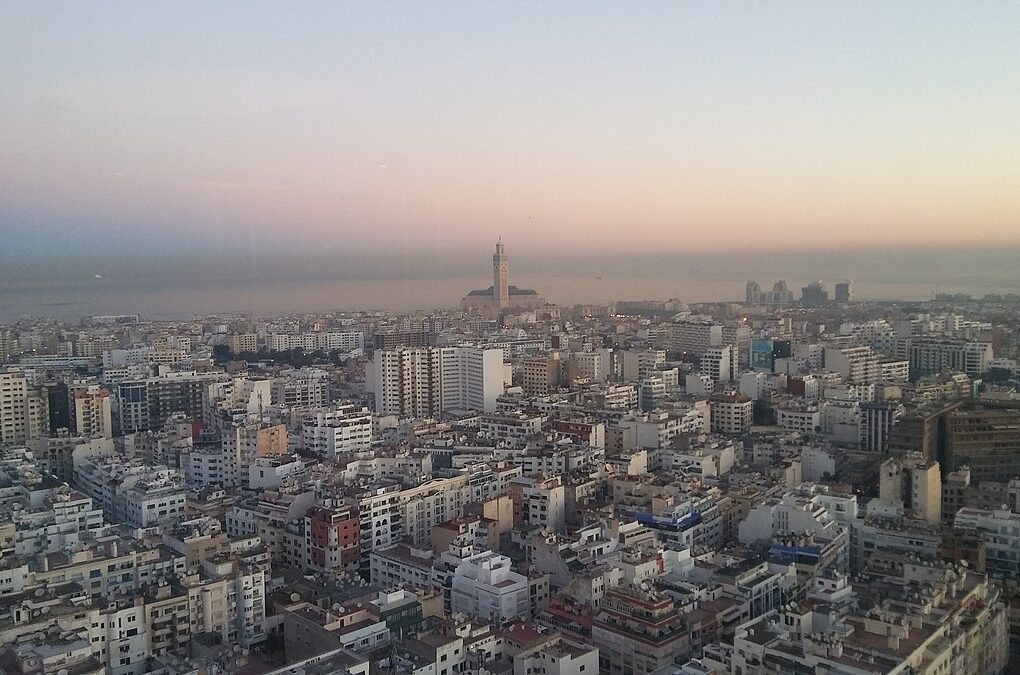 A stunning view of the Hassan II Mosque in Casablanca at sunrise, with warm colors reflecting on the Atlantic Ocean.