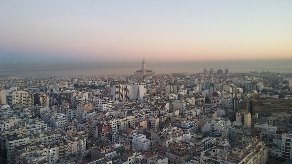 A stunning view of the Hassan II Mosque in Casablanca at sunrise, with warm colors reflecting on the Atlantic Ocean.