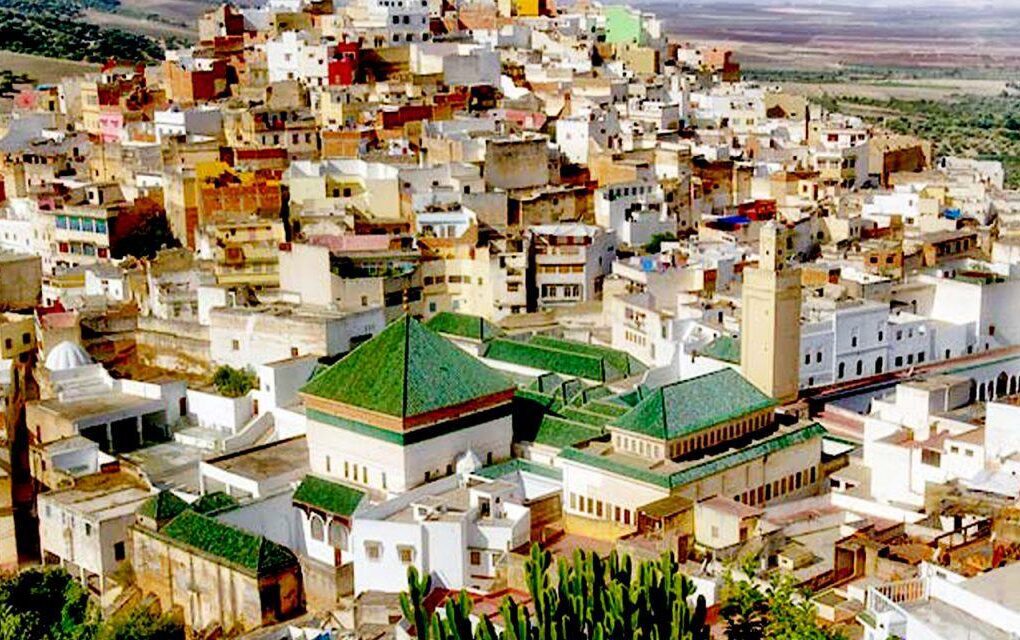 A view of Bab Mansour, the largest gate in Morocco, showcasing intricate arches and colorful mosaic tiles.