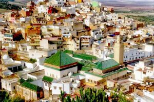 A view of Bab Mansour, the largest gate in Morocco, showcasing intricate arches and colorful mosaic tiles.