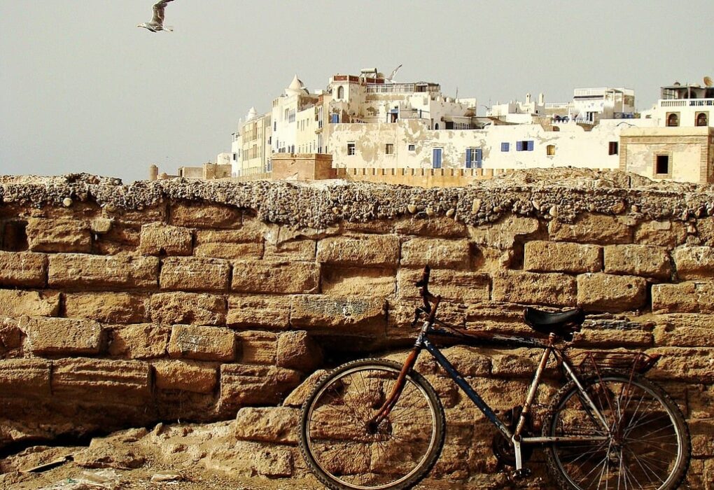 Scenic view of Essaouira, Morocco, showcasing the historic city walls and blue fishing boats at the port.